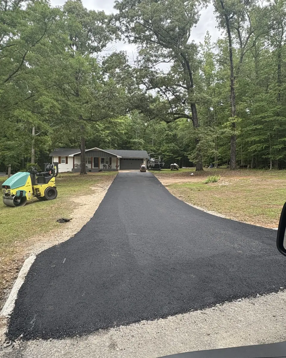 New asphalt driveway with a roller parked at the top, near Jackson Lake in Jasper County, GA